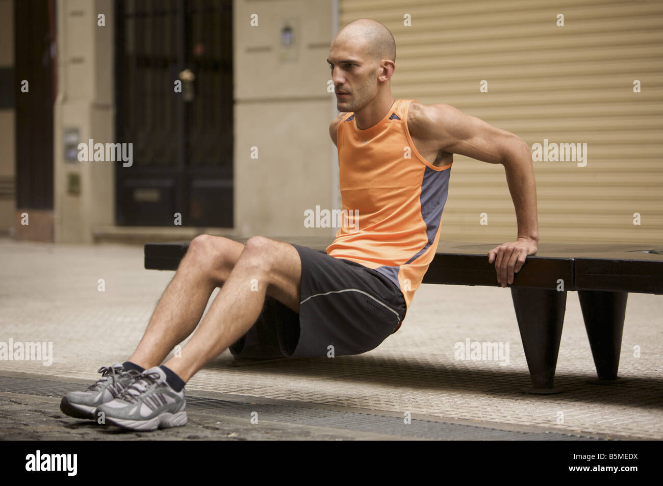 Un homme l'exercice d'un banc de la rue Banque D'Images