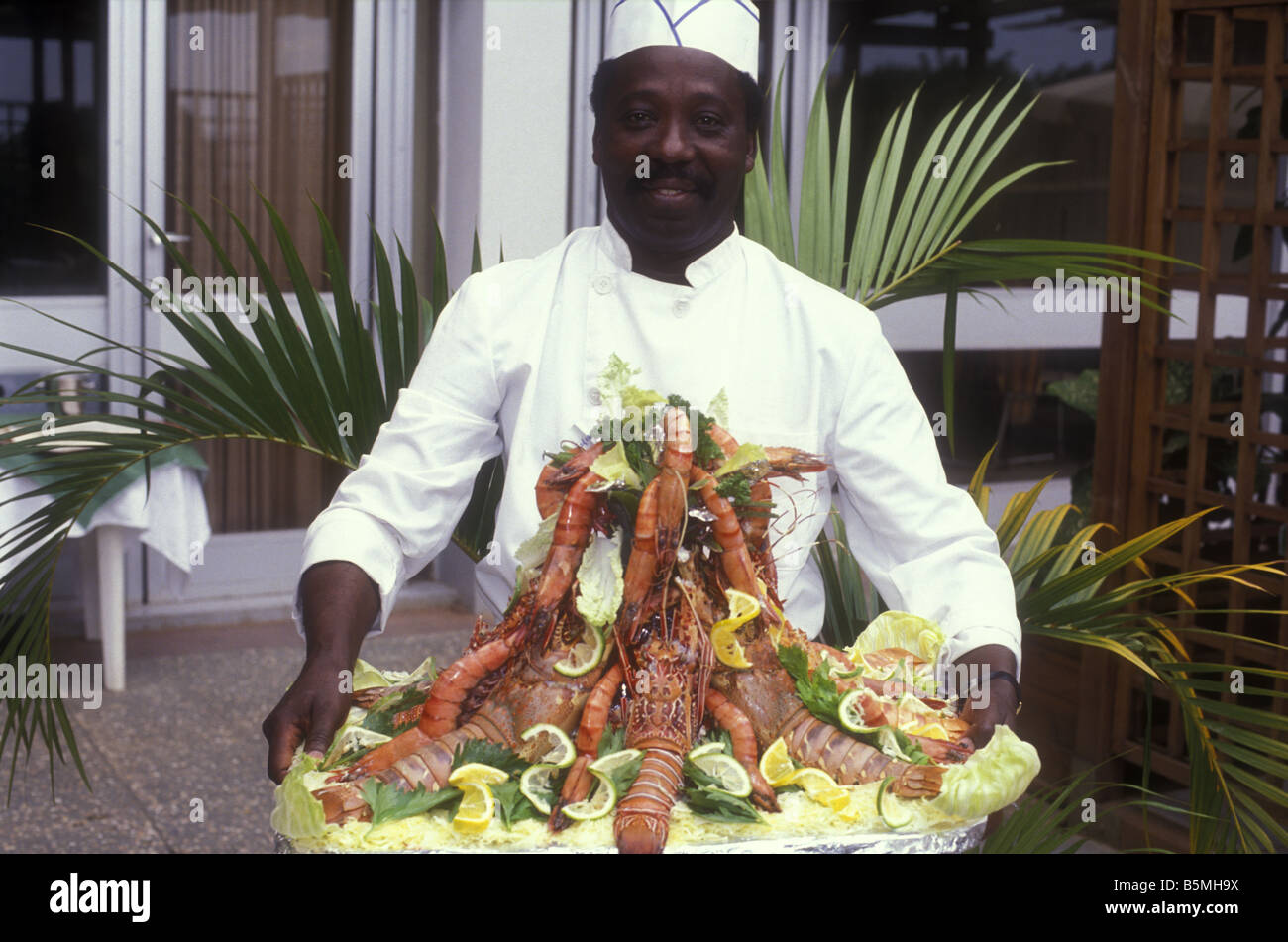 Happy African cuisinier ou cuisinier, transportant des fruits de mer,  assiette de présentation énorme dont du Homard et Langoustines Kampala  Ouganda Afrique Photo Stock - Alamy