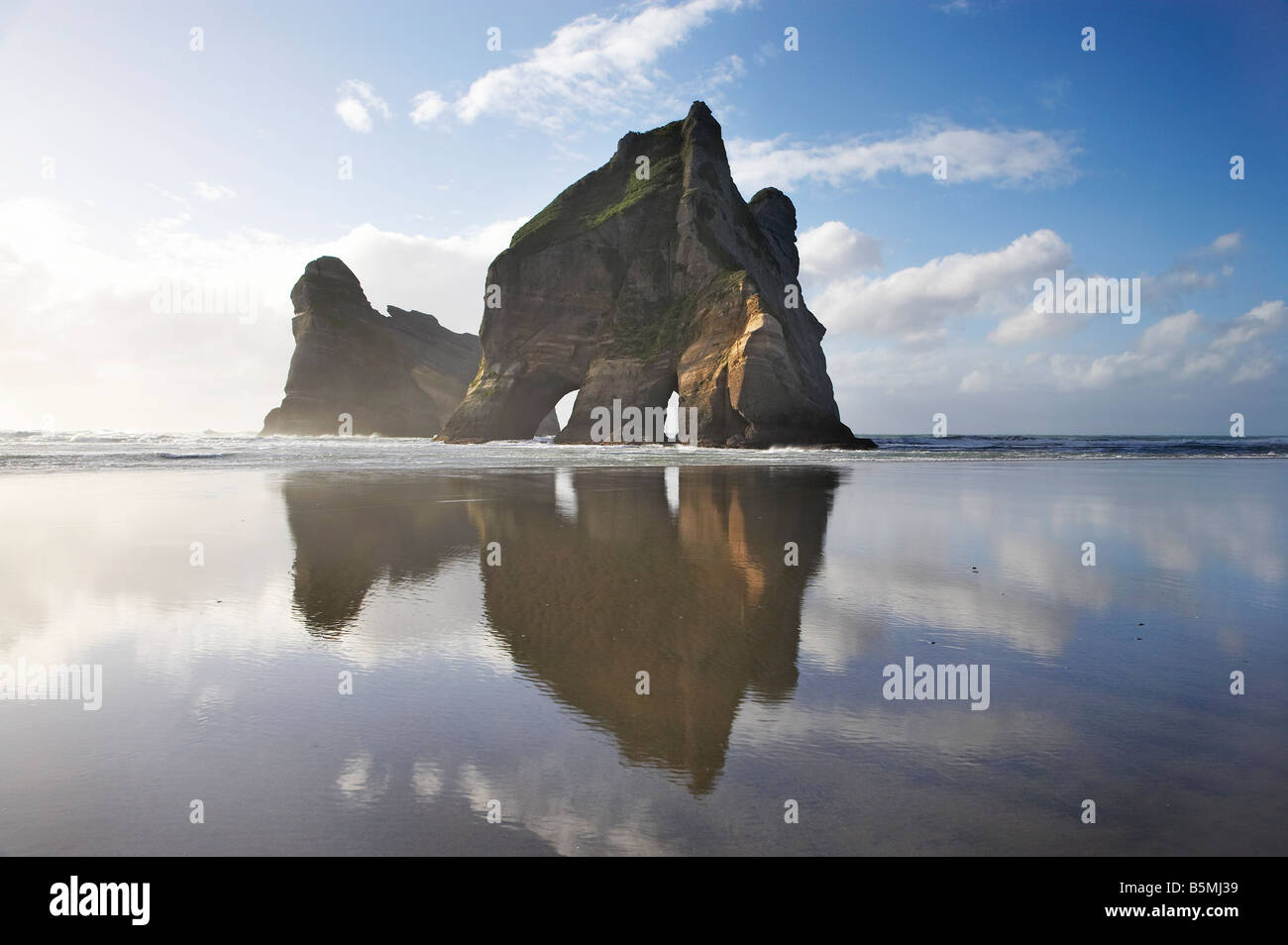 Îles d'Archway reflétée dans les sables humides de Wharariki Beach, près de North West Cape Farewell Nelson Region ile sud Nouvelle Zelande Banque D'Images