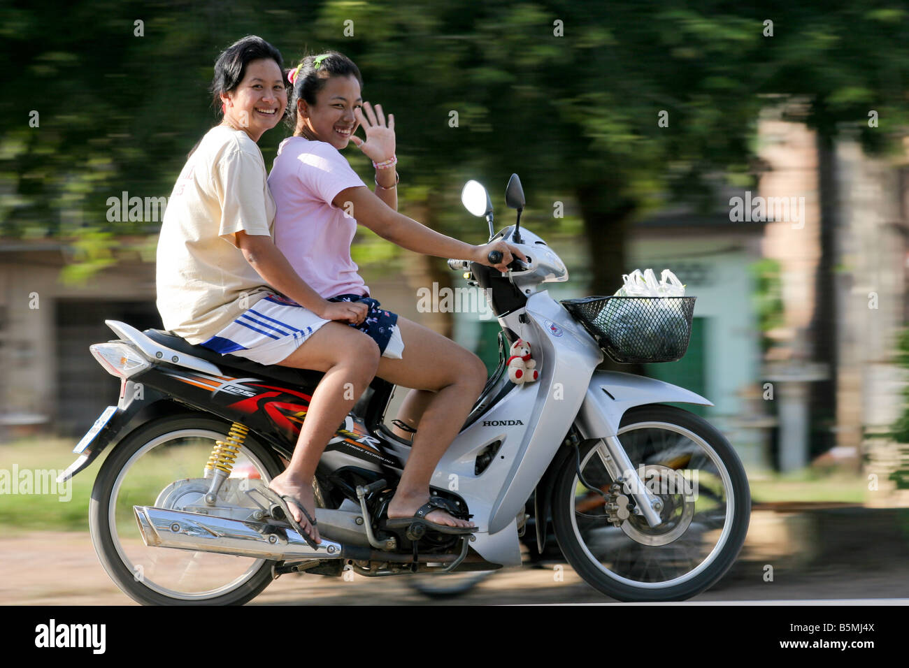 Smiling mother and daughter riding a motorcycle, Khao Sok, Thaïlande Banque D'Images