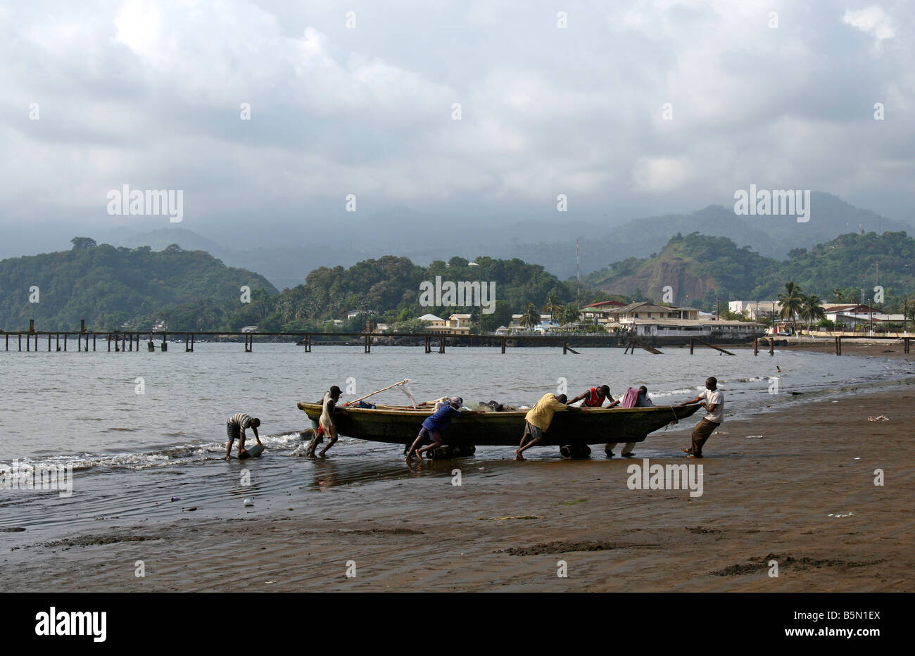 En faisant glisser les pêcheurs en bateau à Limbé Cameroun Afrique de l'Ouest Le Mont Cameroun en arrière-plan Banque D'Images