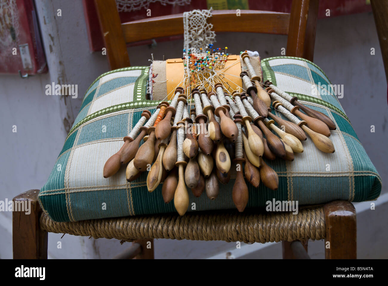 Le travail de la dentelle complexe se trouve sur l'affichage sur une chaise le long de la rue dans le Puy en Velay, Haute Loire, Auvergne, France Banque D'Images