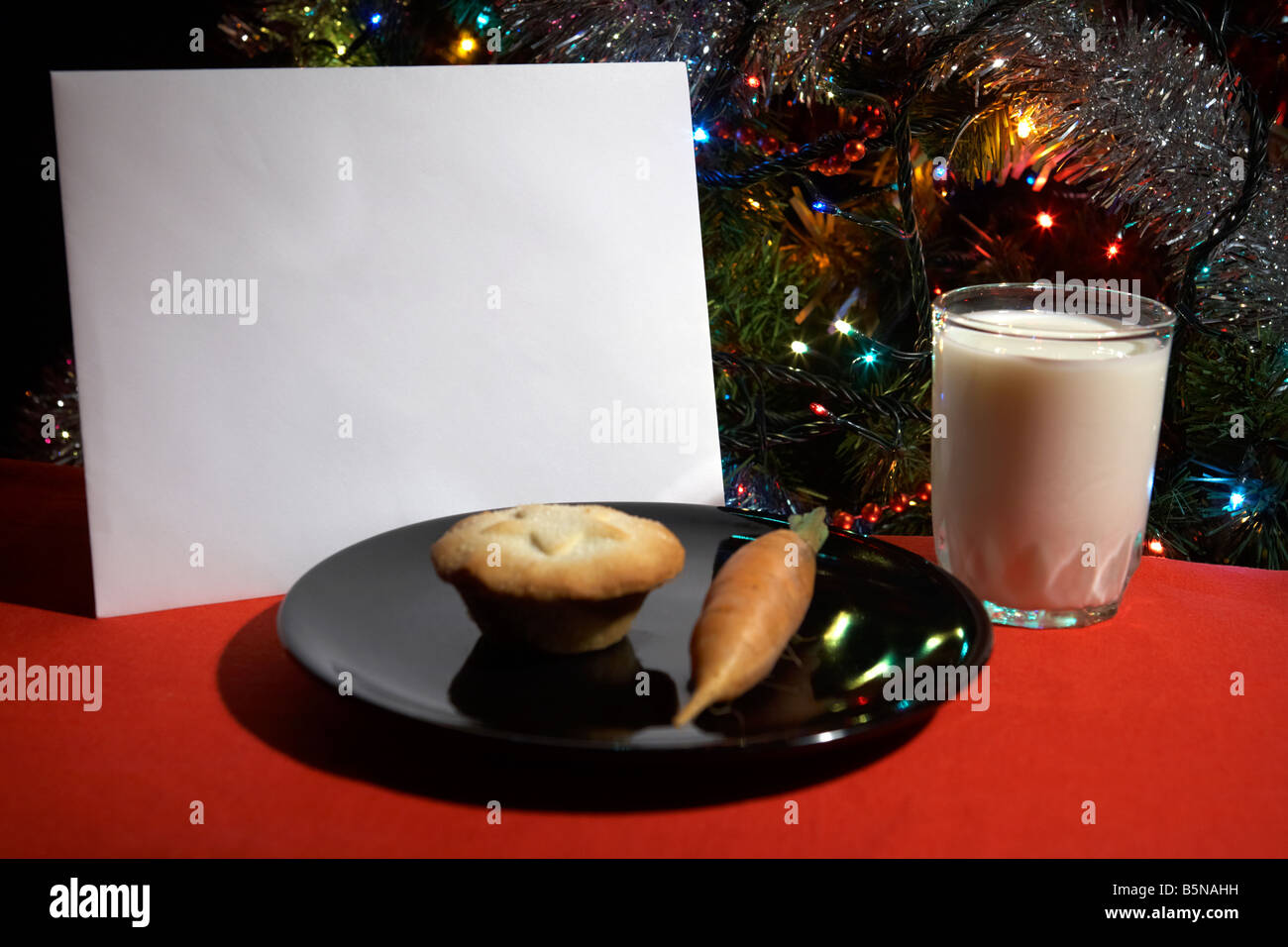 Lettre laissée la veille de Noël avec mince pie carotte et verre de lait in front of Christmas Tree Banque D'Images