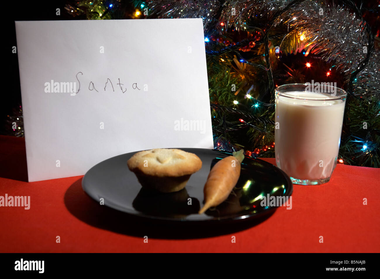 Childs lettre au père laissés la veille de Noël avec mince pie carotte et verre de lait in front of Christmas Tree Banque D'Images
