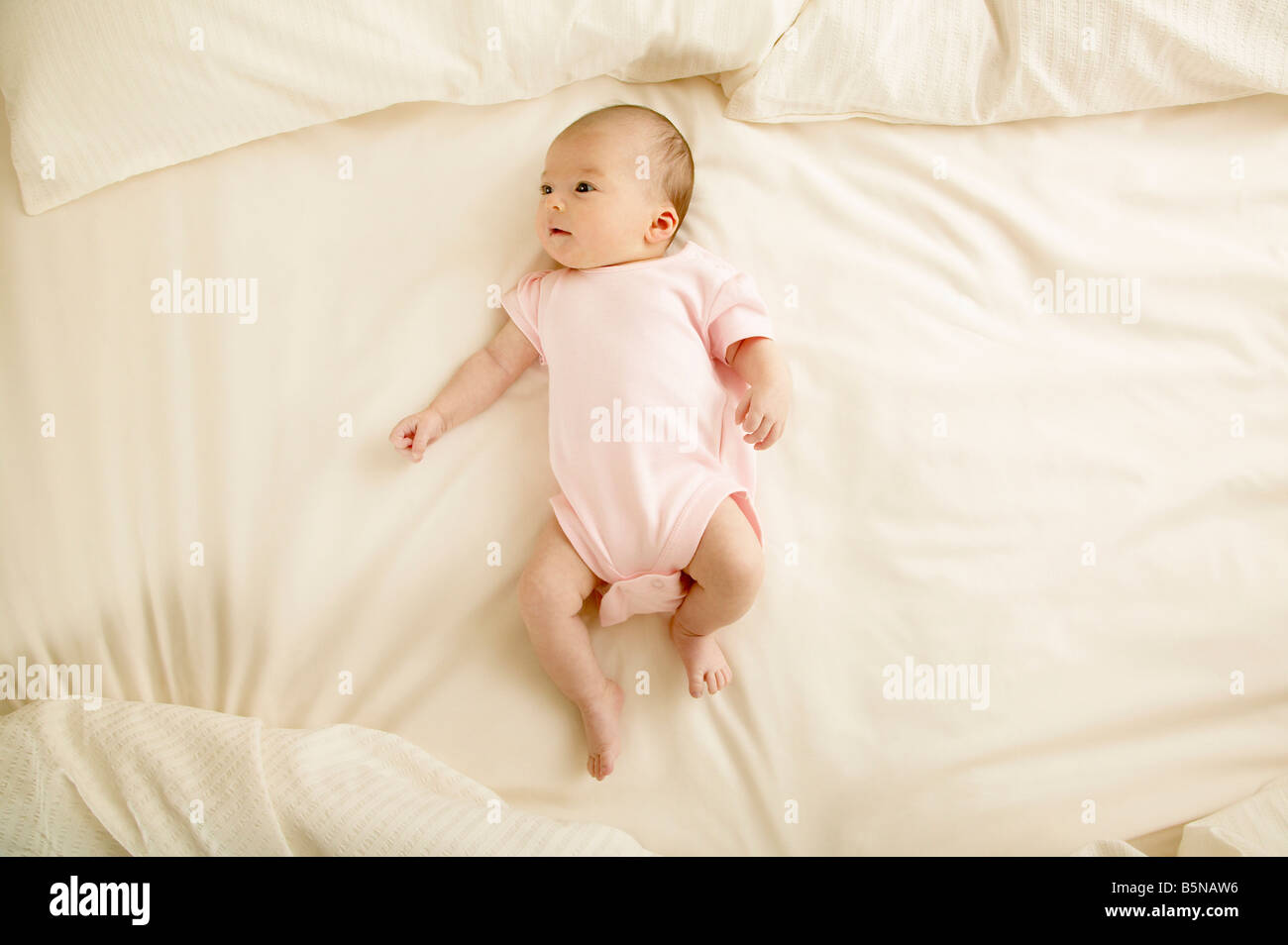 Bébé fille (1 mois) lying on bed Photo Stock - Alamy
