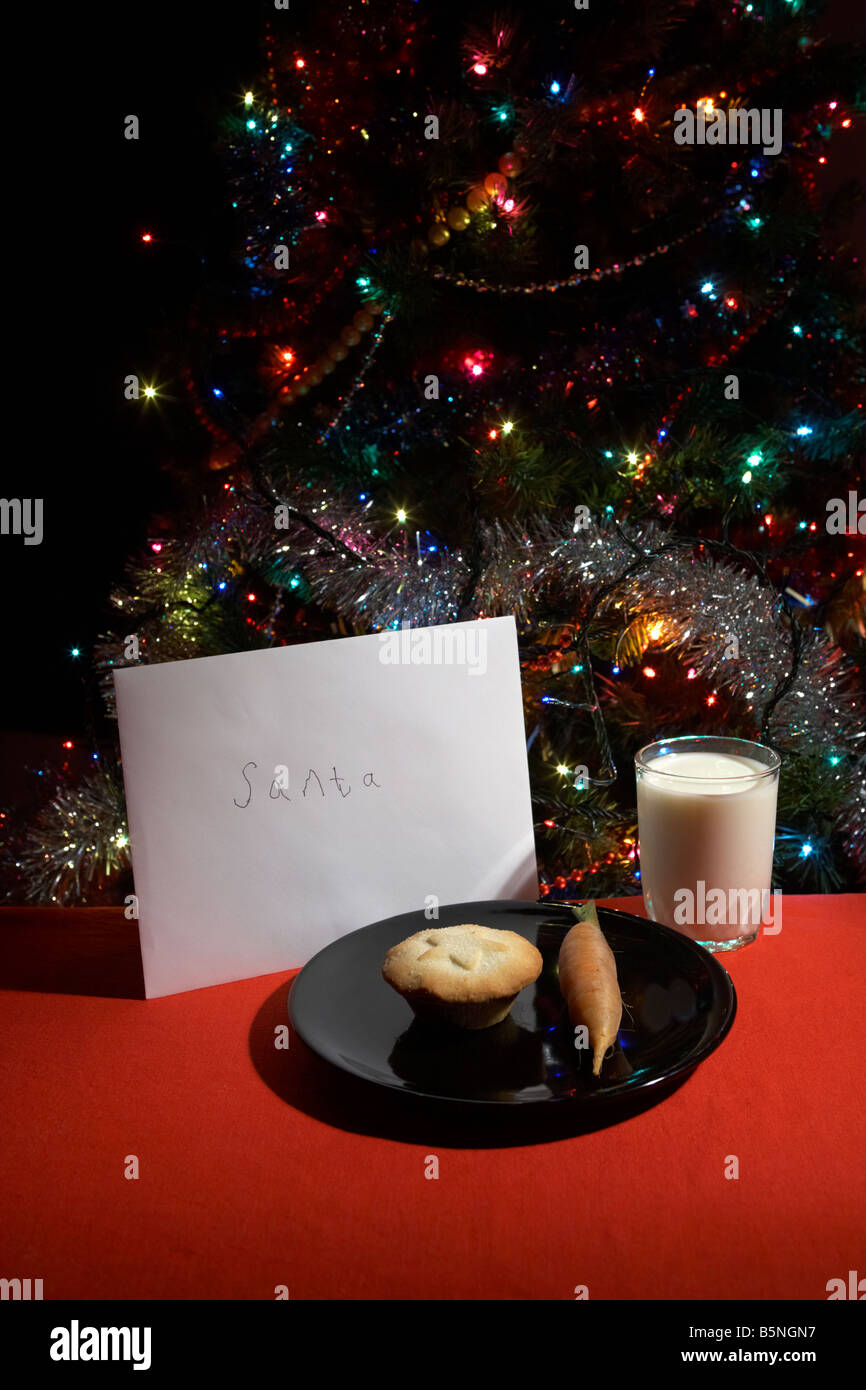 Childs lettre au père laissés la veille de Noël avec mince pie carotte et verre de lait in front of Christmas Tree Banque D'Images
