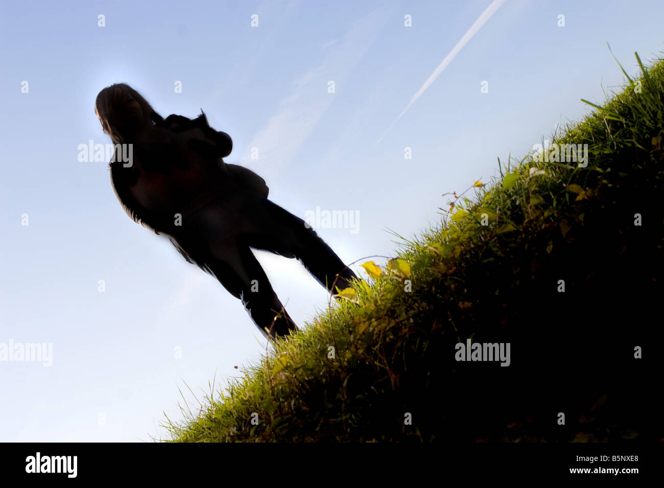 Une jeune étudiante posant sur une colline herbeuse sur le campus de l'école Banque D'Images