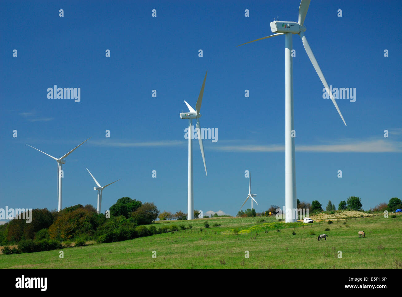 Cinq éoliennes du parc éolien sur le ciel bleu et le champ vert - France Banque D'Images