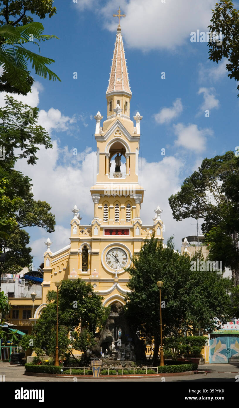 Église catholique de jaune et blanc de Cha Tam avec une statue de saint François Xavier situé en hauteur dans la spire, Chinatown, Cholon, Ho Chi Minh, Vietnam Banque D'Images