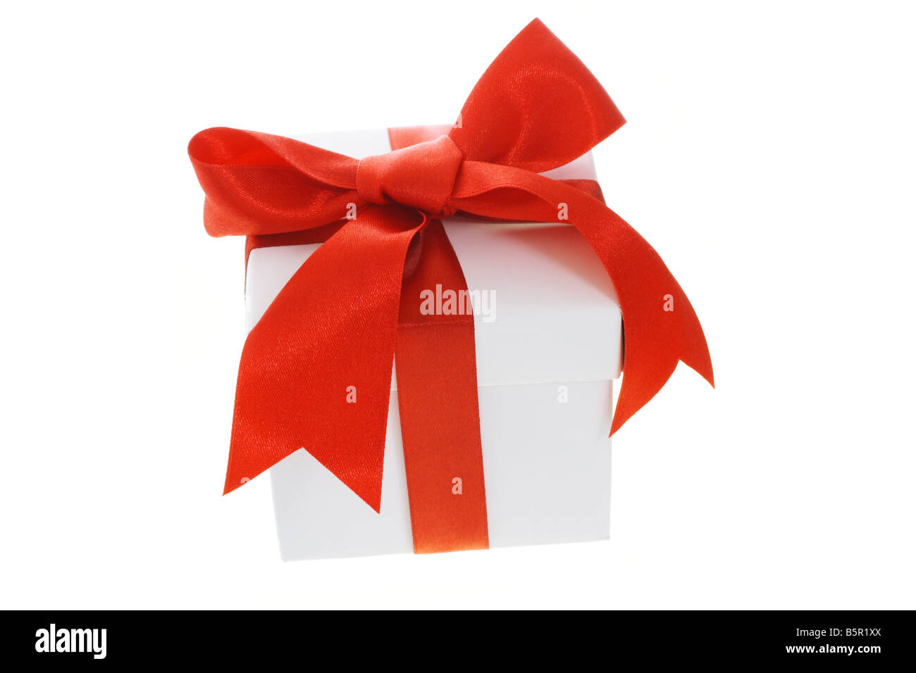 Boîte-cadeau avec arc rouge ruban sur fond blanc Banque D'Images