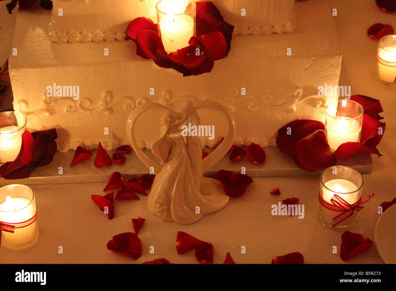 Un gâteau de mariage de fantaisie avec des bougies allumées autour du cake affiché pour une réception de mariage Banque D'Images