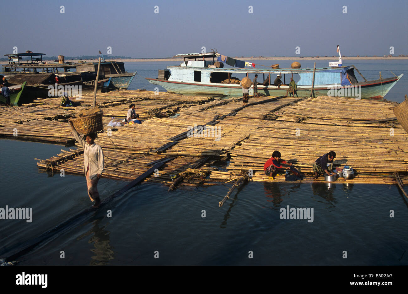 Bois de chauffage de déchargement d'un bateau sur le Fleuve Irrawaddy en Birmanie ou Myanmar Mandalay Banque D'Images
