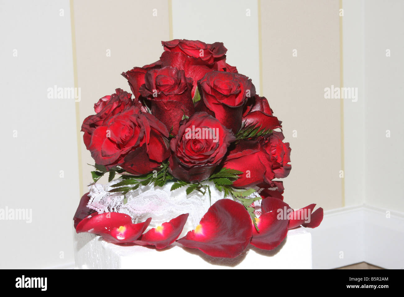 Un beau gâteau de mariage avec des roses rouges en haut affiche pour une réception de mariage Banque D'Images