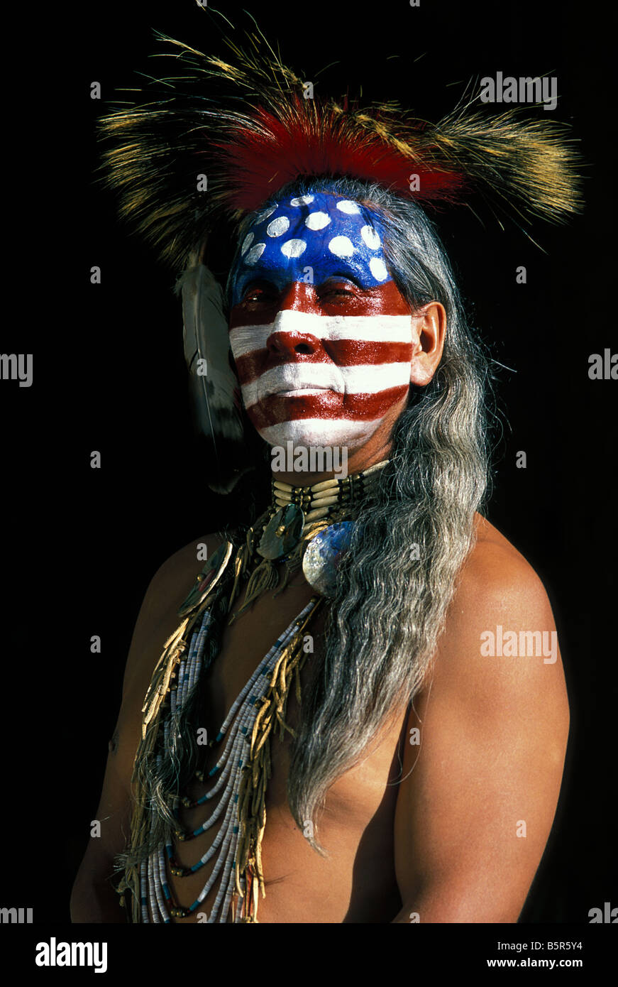 Portrait d'un homme amérindien avec des étoiles peintes en rouge, blanc et bleu et des bandes du drapeau américain, USA. Un symbole de liberté et de protestation. Banque D'Images