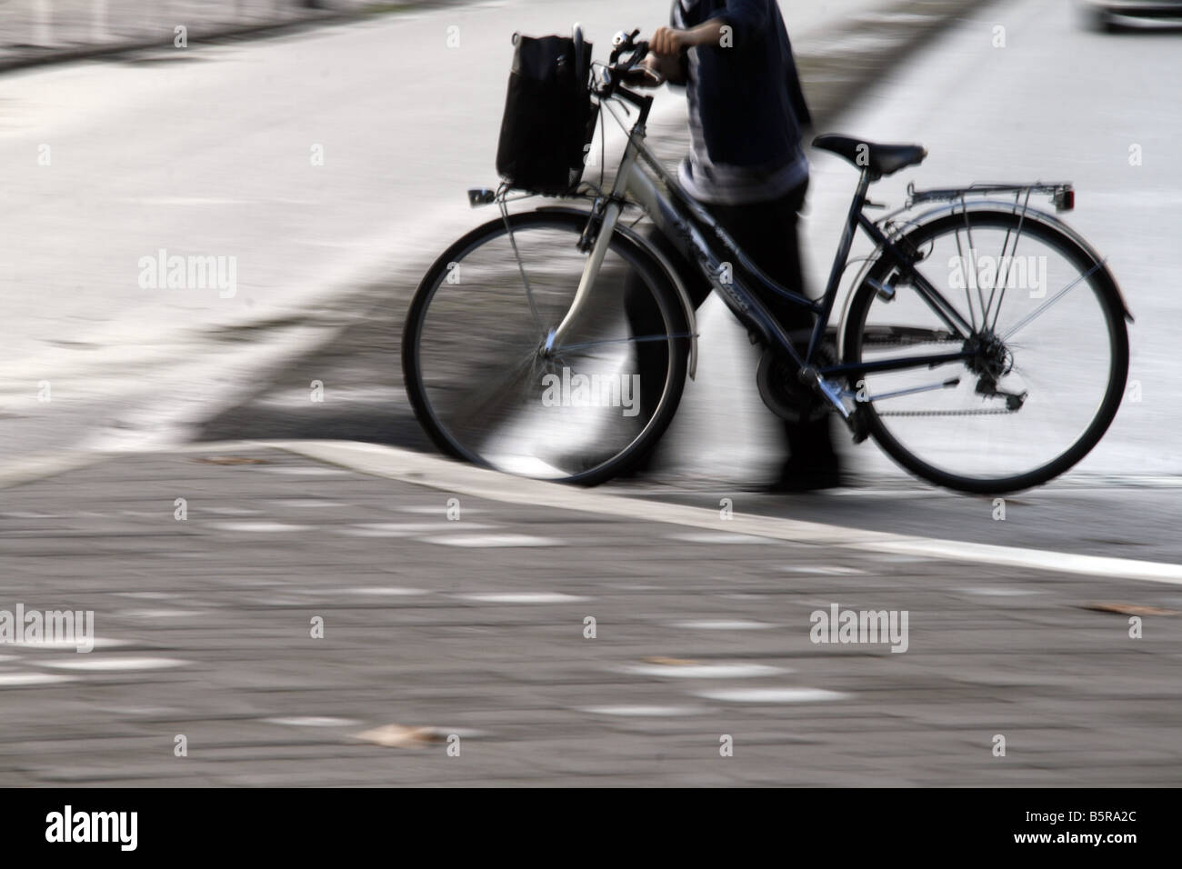 Jeune femme en poussant le vélo sur rue en ville Banque D'Images