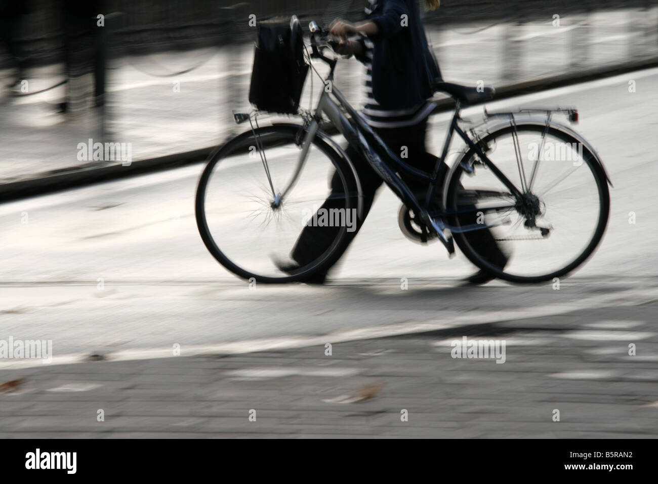 Jeune femme en poussant le vélo sur rue en ville Banque D'Images