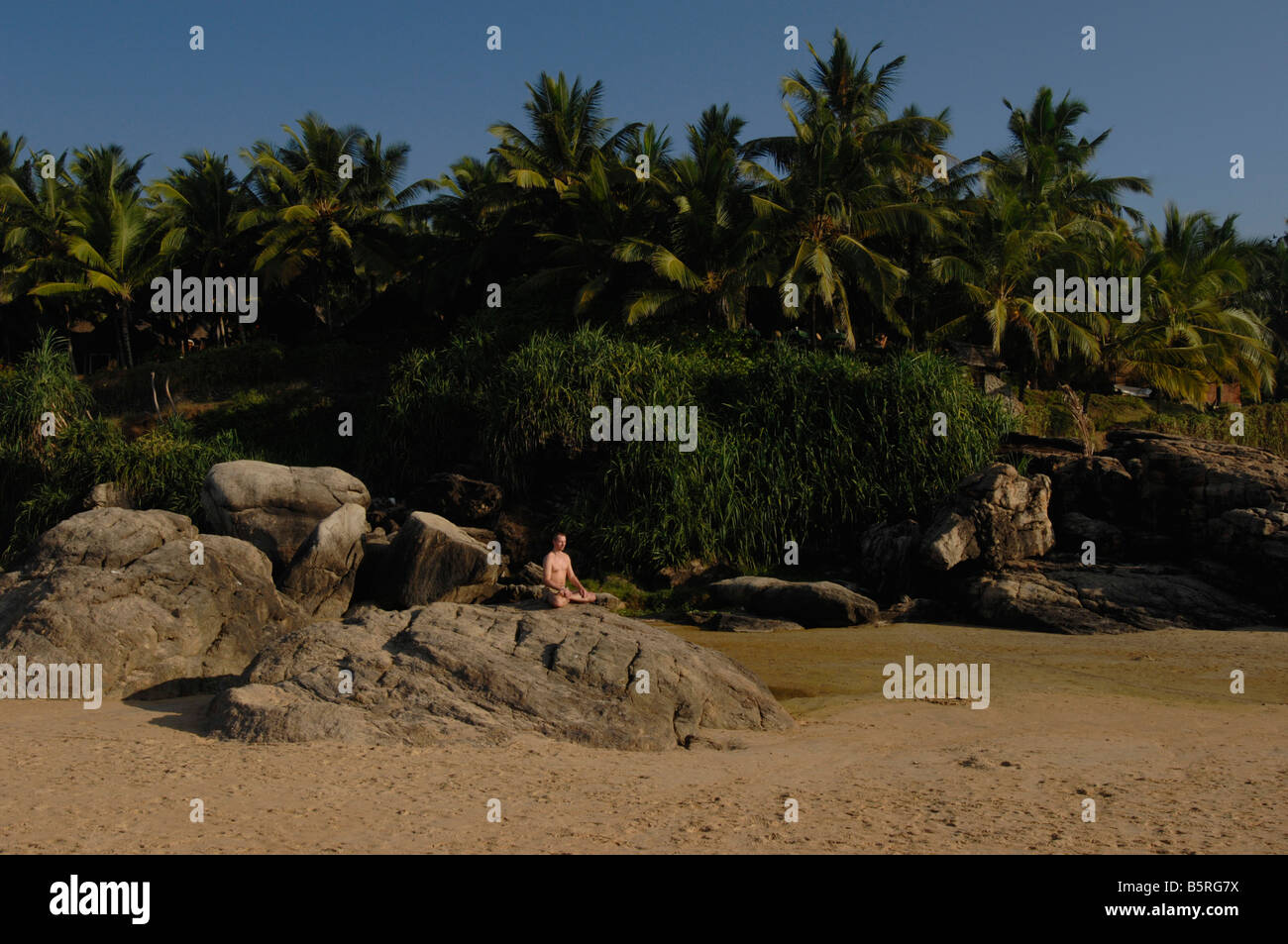 Un homme médite sur Chowara beach, Inde du Sud Banque D'Images