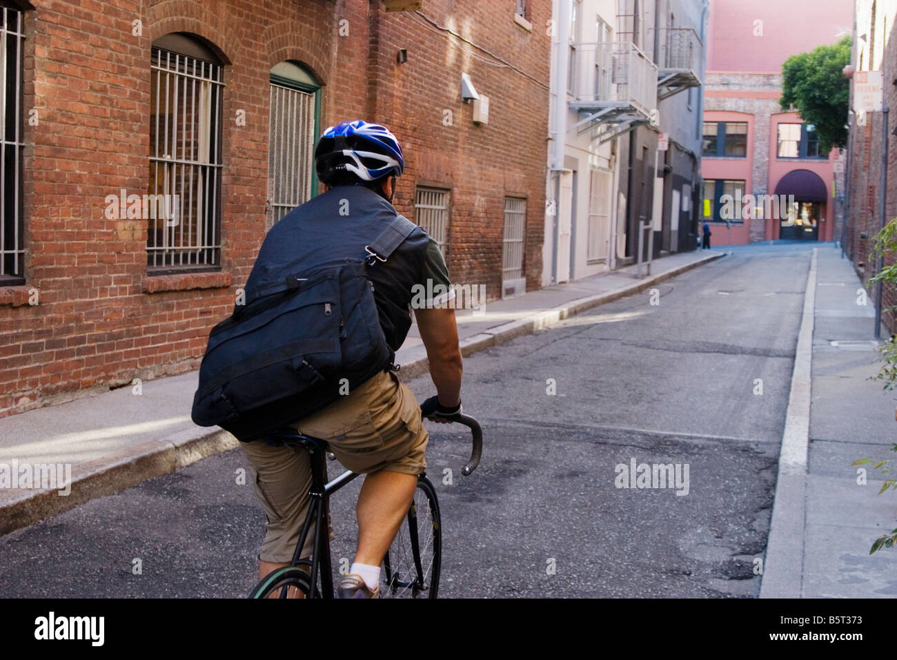 Bike messenger vue arrière à travers une ruelle San Francisco California USA Banque D'Images