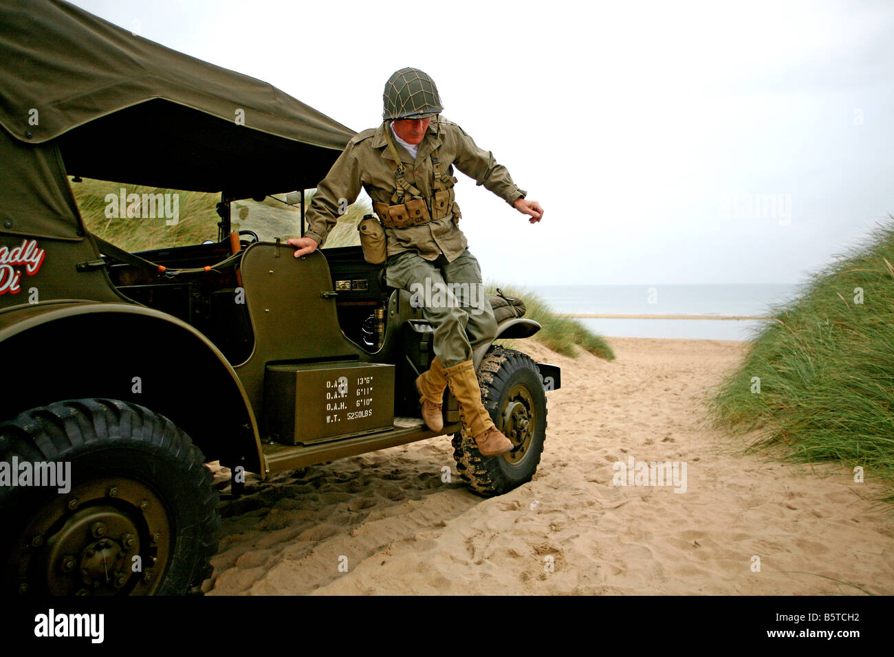 Acteur habillé en D-Day soldat américain saute vers le bas à partir d'un Dodge voiture commande sur Utah Beach Normandie ,France Banque D'Images