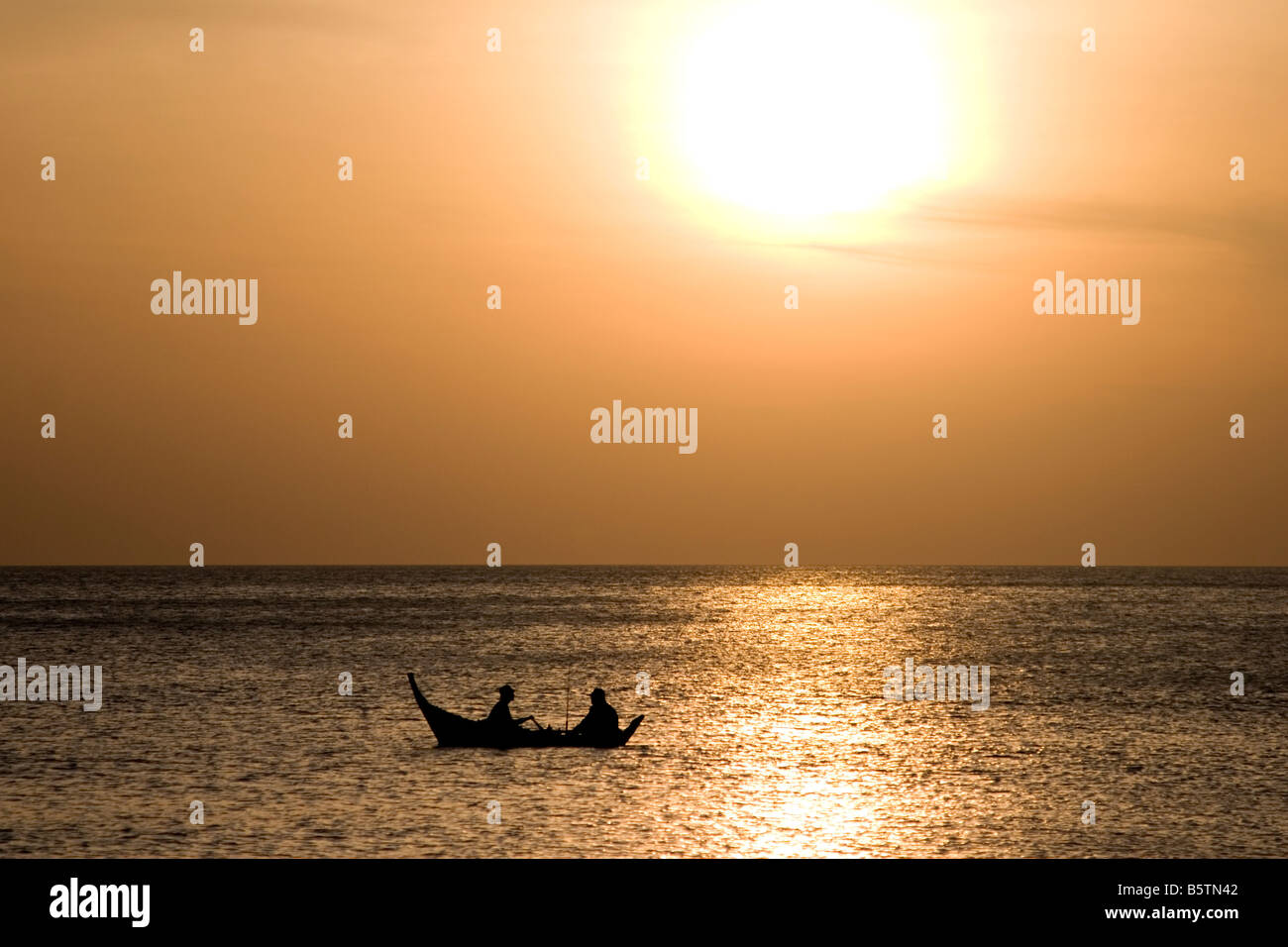 Pagayer dans un canot en bois rustique dans la mer d'Andaman au large de la Thaïlande. Banque D'Images