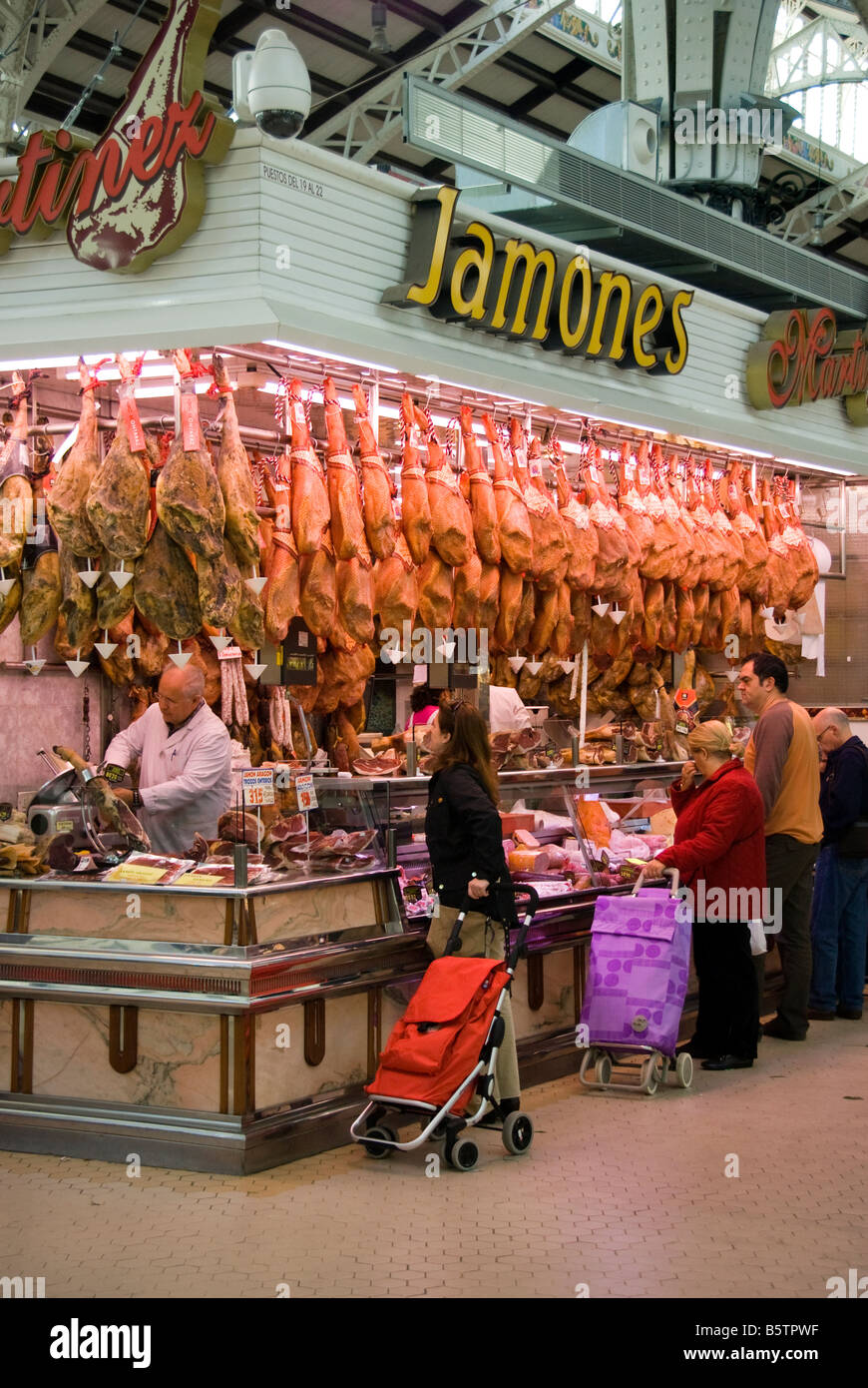 Espagnols shopping à un décrochage de la viande au marché central Mercado Central dans le centre-ville historique de Valence Espagne Banque D'Images