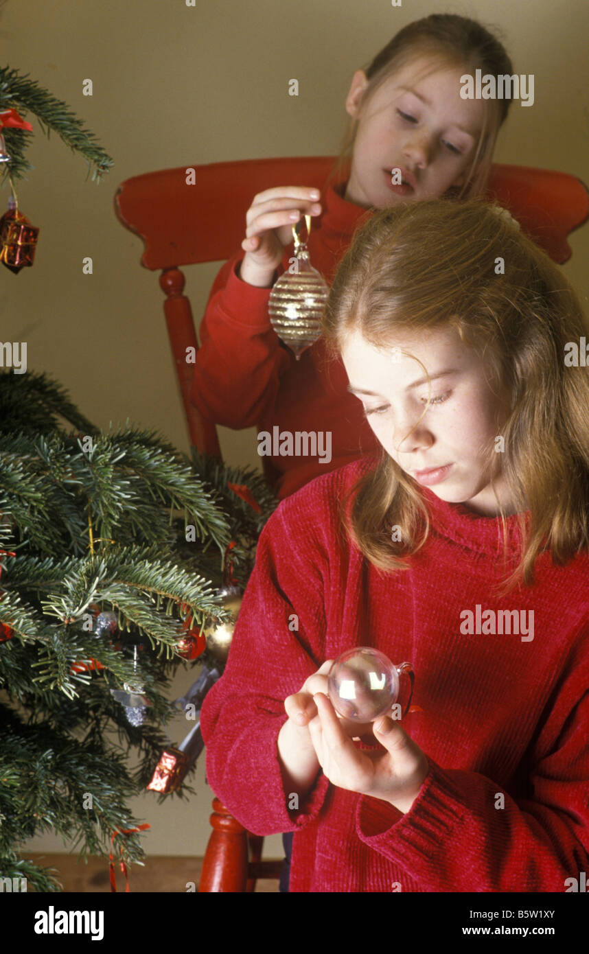 2 jeunes filles à la recherche de babioles comme ils décorent l'arbre de Noël Banque D'Images