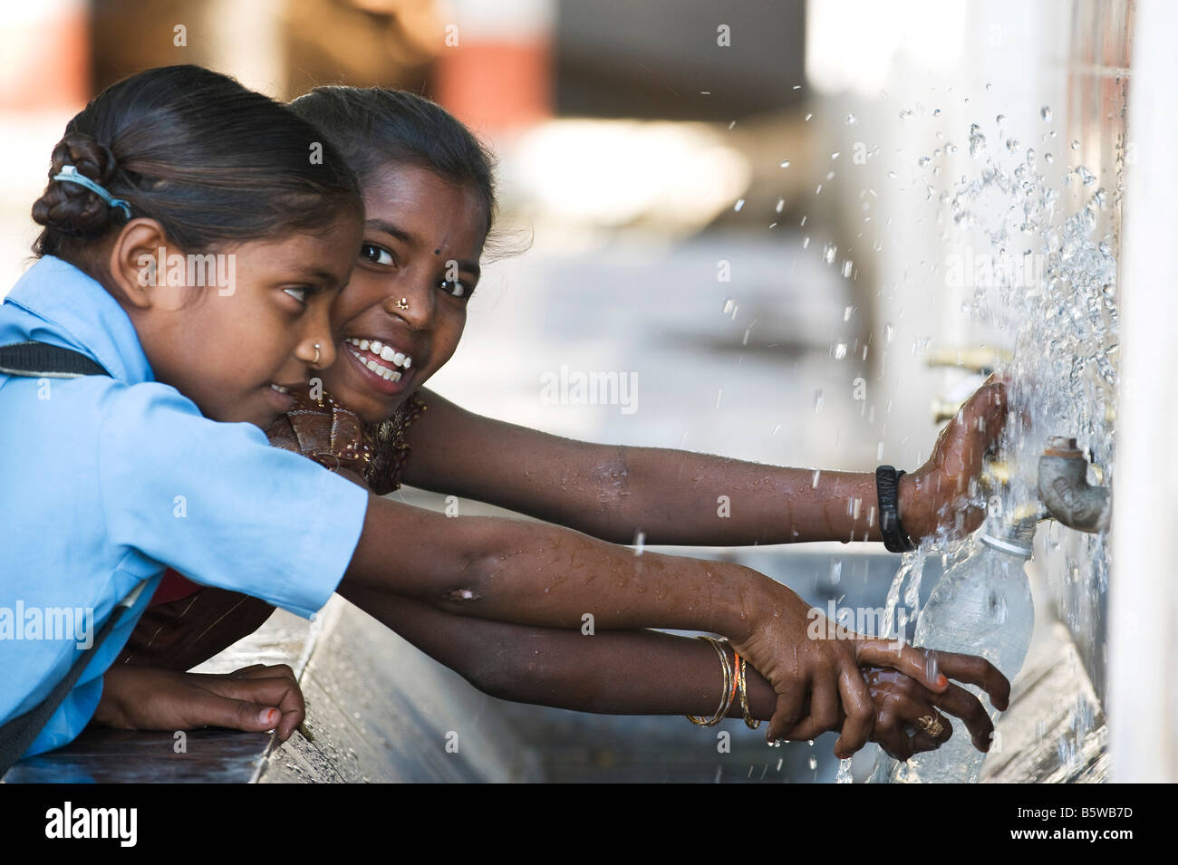 Deux filles indiennes de remplir une bouteille d'eau. Kadiri, Andhra Pradesh, Inde Banque D'Images