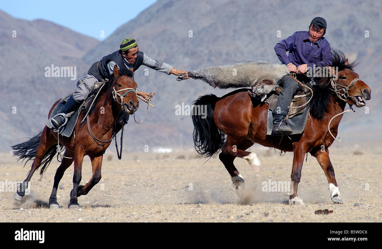 Deux coureurs kazakhs lutte pour le contrôle d'une chèvre morte dans un jeu de Kokpar Bushkashi ou à l'assemblée annuelle du Festival de chasse de l'Aigle Banque D'Images