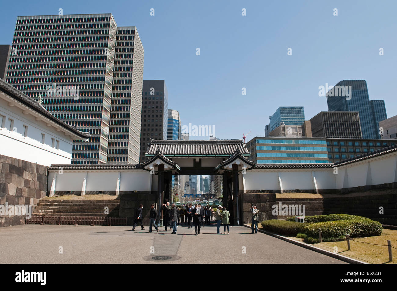 Touristes de l'Ote-mon Porte du Palais Impérial, Tokyo, Japon, dominé par des immeubles de bureaux Banque D'Images