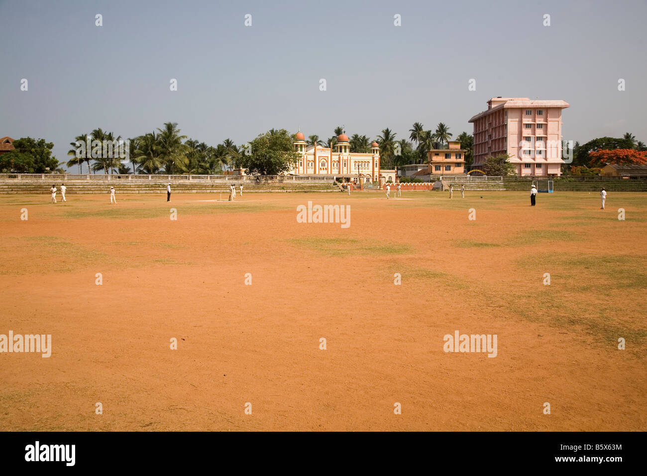 Le Cricket se joue sur un guichet poussiéreux à Thalassery au Kerala, en Inde. Banque D'Images