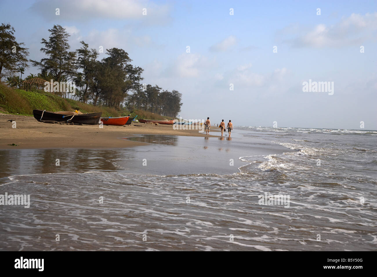 Les touristes et les bateaux de pêche traditionnels, Goa Arambol Beach, Goa, Inde Banque D'Images
