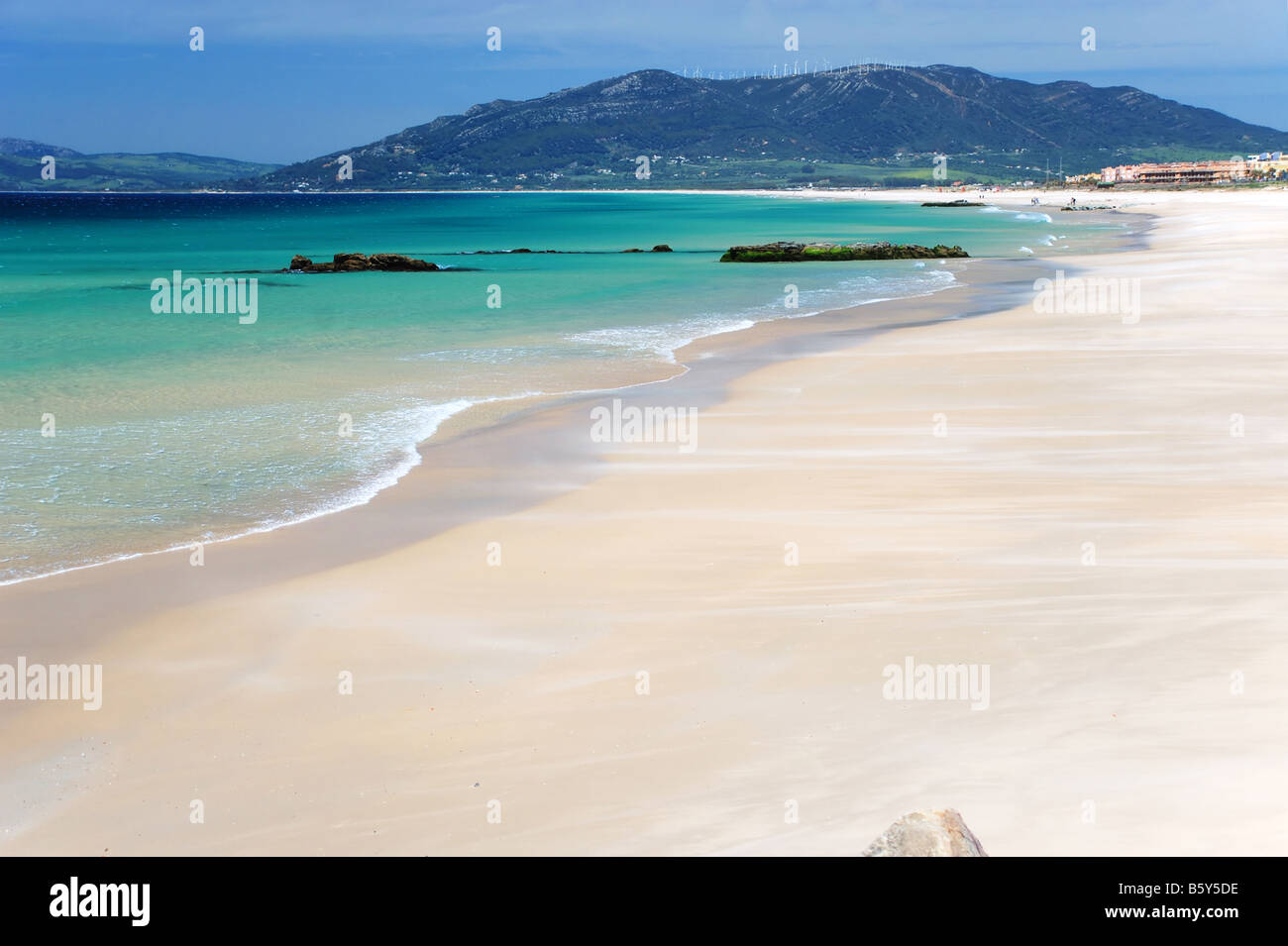 Vagues de sable sur la mer d'azur plage et ciel bleu profond montagnes méditerranéennes dans l'arrière-plan Banque D'Images