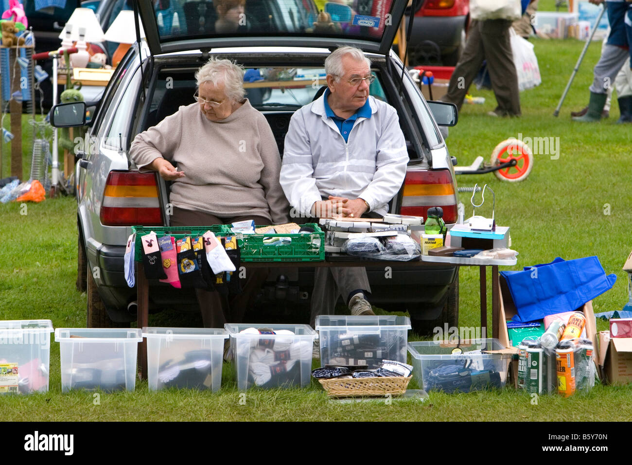 Couple de personnes âgées de vendre des objets à un vide grenier dans le bourg de Banbury Oxfordshire England Banque D'Images
