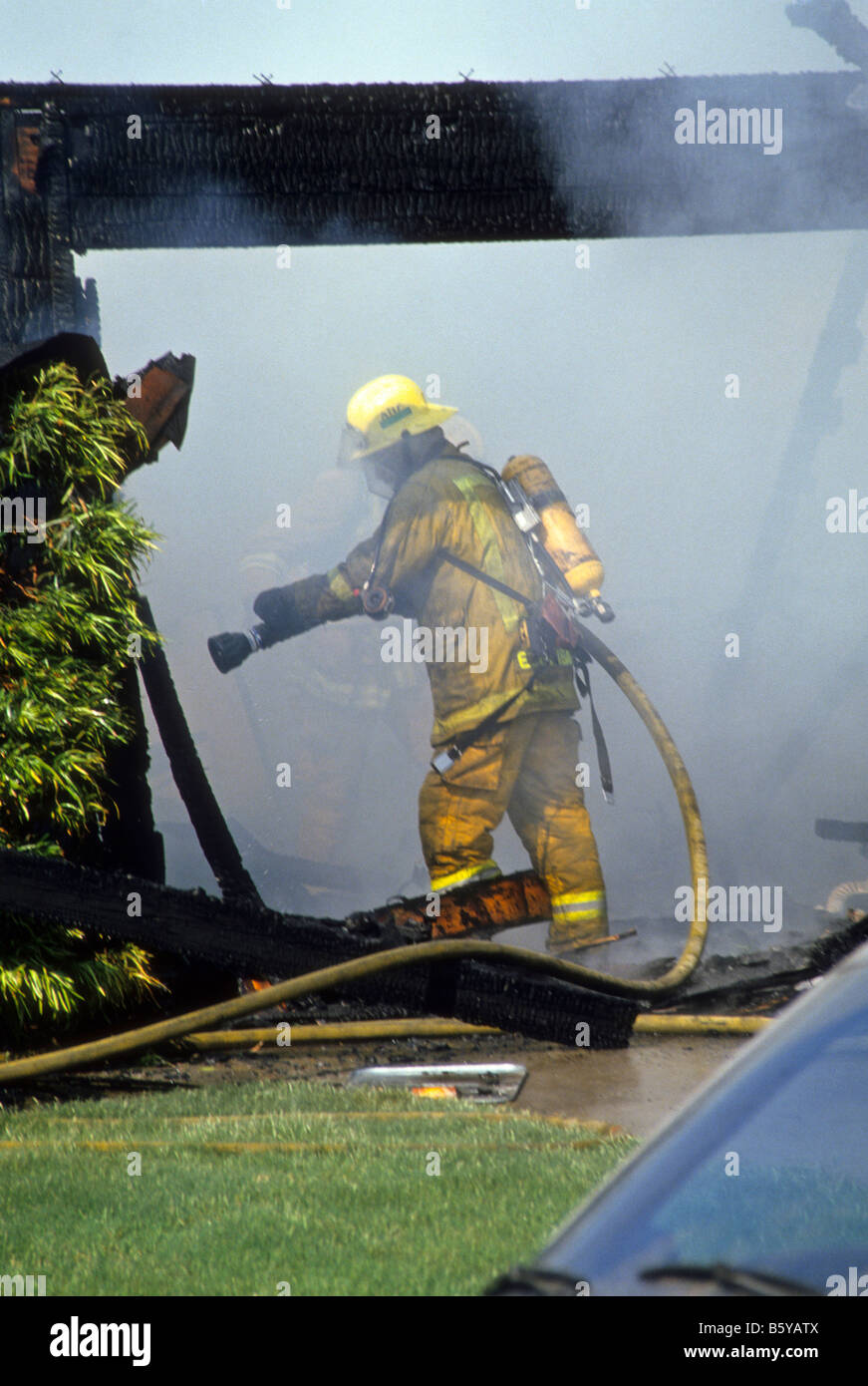Les pompiers entrer garage rempli de fumée pour combattre l'incendie. Banque D'Images