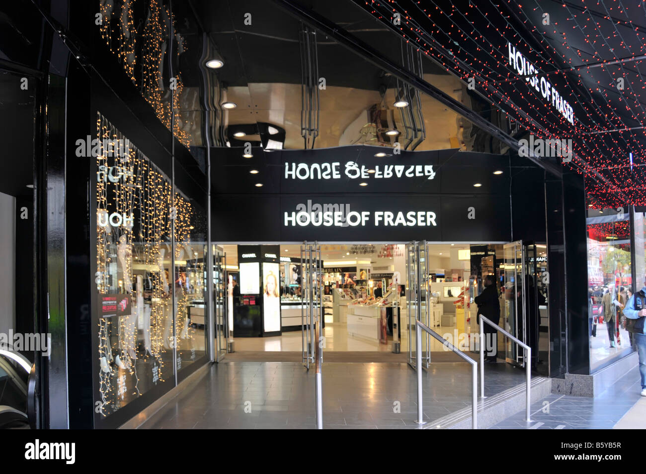 Les lumières de Noël et shopping à House of Fraser Ministère de l'entrée du magasin d'Oxford Street, à l'entrée de l'acheteur à Noël temps West End London England UK Banque D'Images