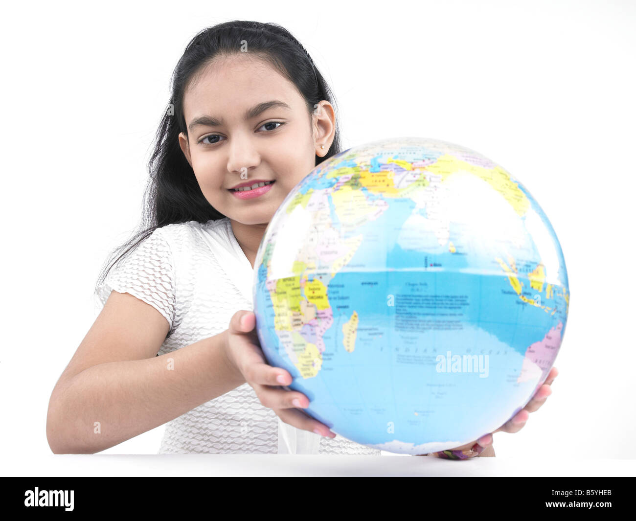 A cute asian teenage girl d'origine indienne holding a globe Banque D'Images