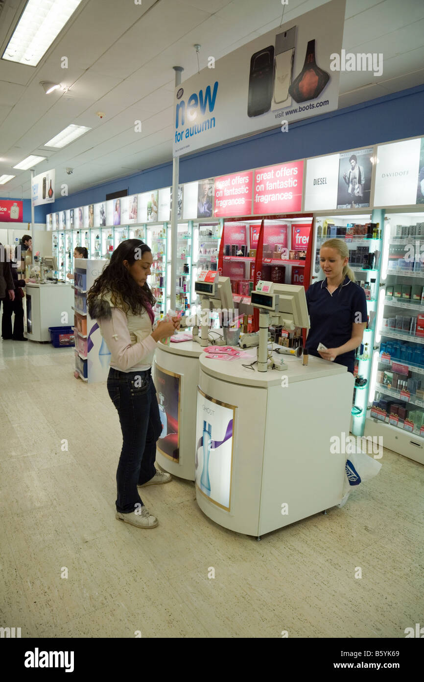 Une adolescente l'achat d'articles en Boots the Chemist, Lion Yard, Cambridge, Royaume-Uni Banque D'Images