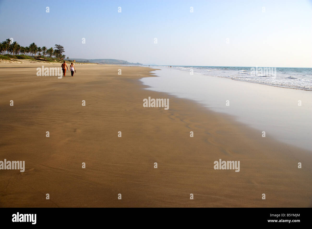 Couple en train de marcher le long de la plage déserte, Arambol Goa, Inde Banque D'Images