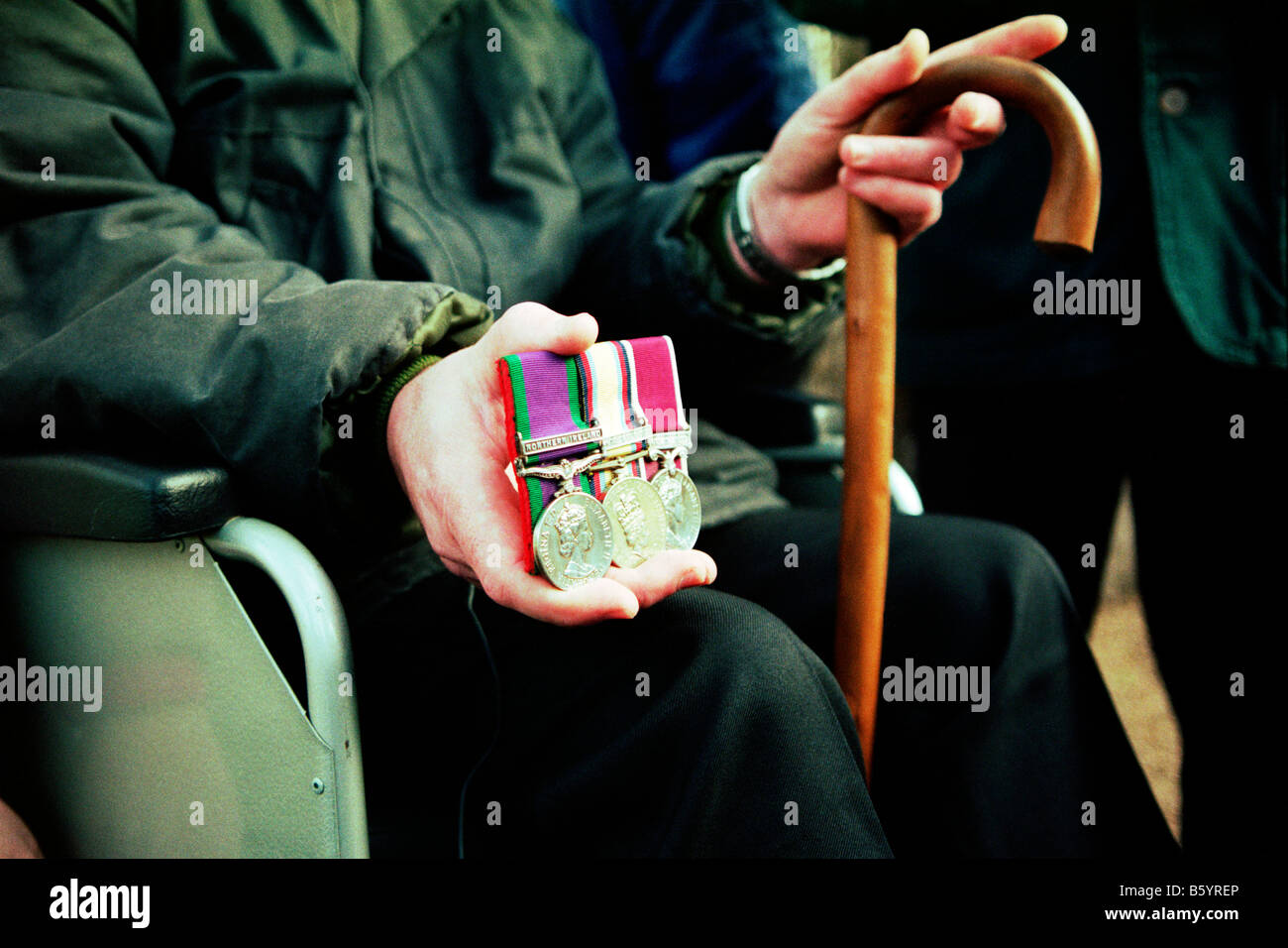 Fauteuil roulant british ancien combattant de la guerre du golfe détient ses médailles à l'extérieur du ministère de la défense siège à Londres au cours d'une manifestation du syndrome de la guerre du Golfe Banque D'Images