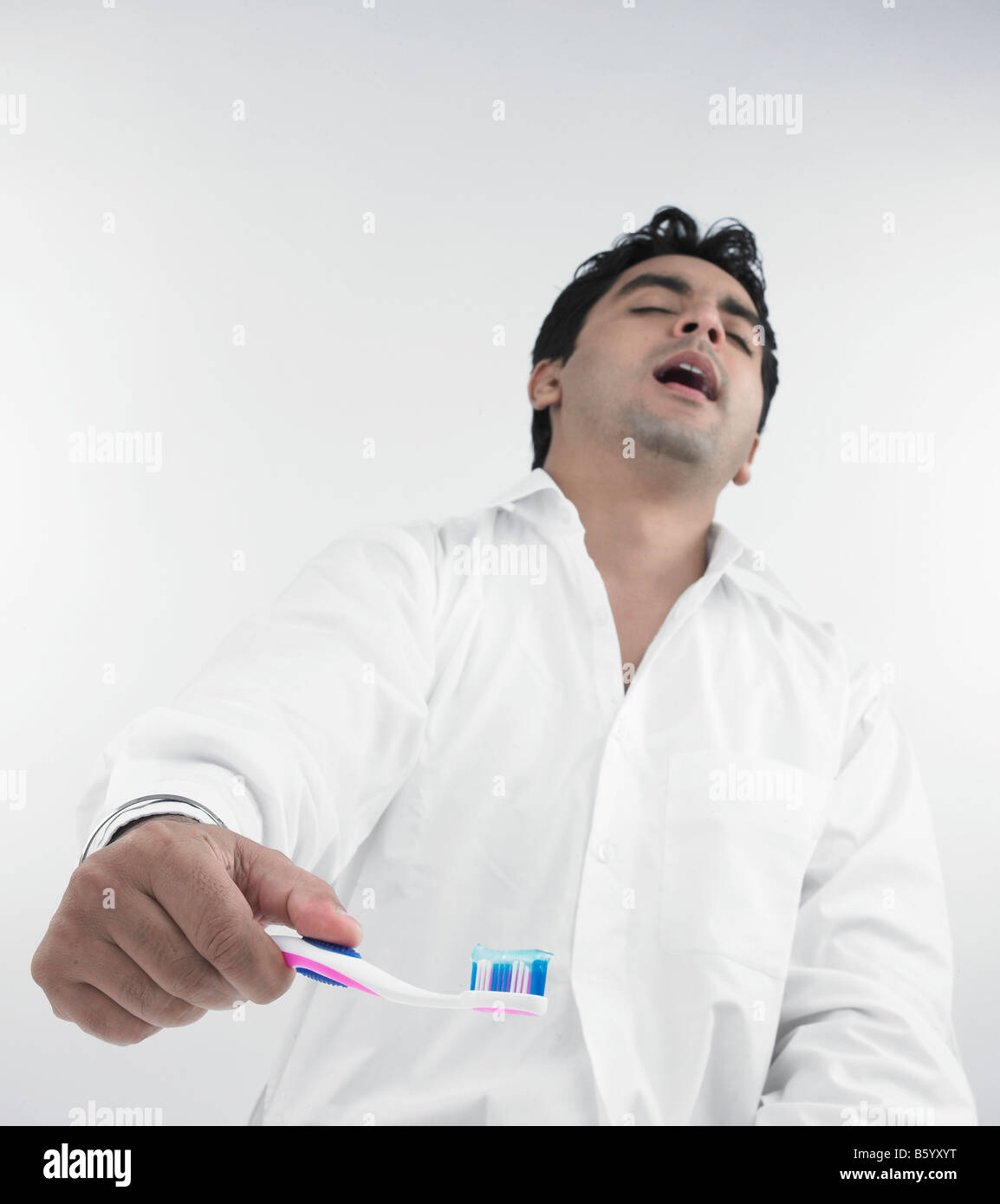 Un bel homme asiatique d'origine indienne se brosser les dents Banque D'Images