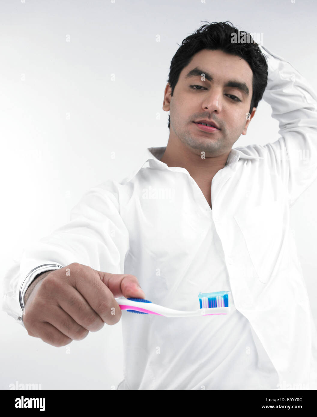 Un bel homme asiatique d'origine indienne se brosser les dents Banque D'Images