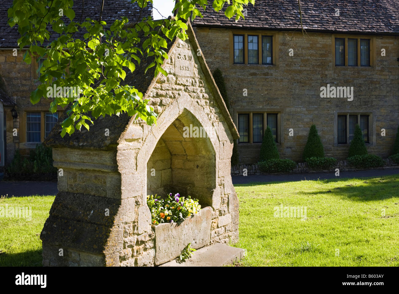 Tôt le matin, la lumière sur l'alimentation en eau dans l'ancien village de Cotswold de Lower Slaughter, Gloucestershire Banque D'Images