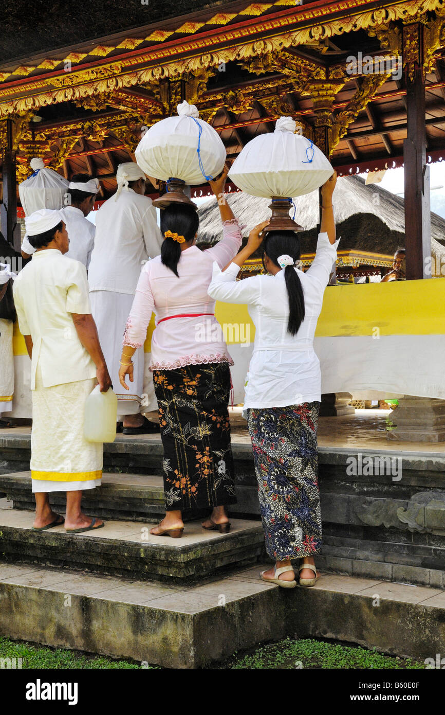 Portant des offrandes à Pura Ulun Danu Temple sur le lac Bratan, Bali, Indonésie Banque D'Images