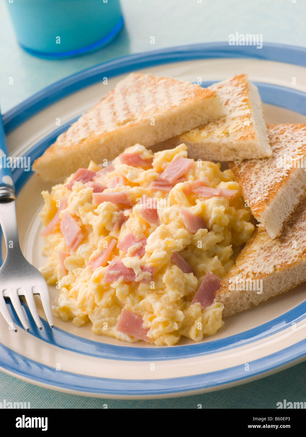 Oeufs brouillés au fromage et jambon grillé et triangles Banque D'Images