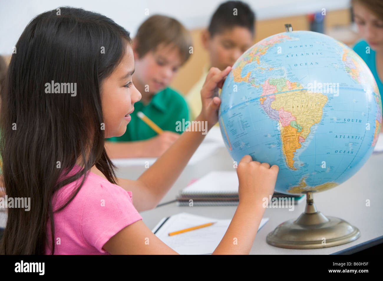 Student in class pointant sur un globe (selective focus) Banque D'Images