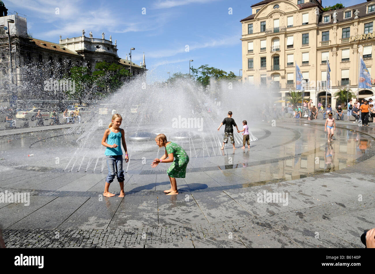 Enfants jouant dans une fontaine, la place Karlsplatz, connu sous le nom de Stachus, Munich, Bavière Banque D'Images