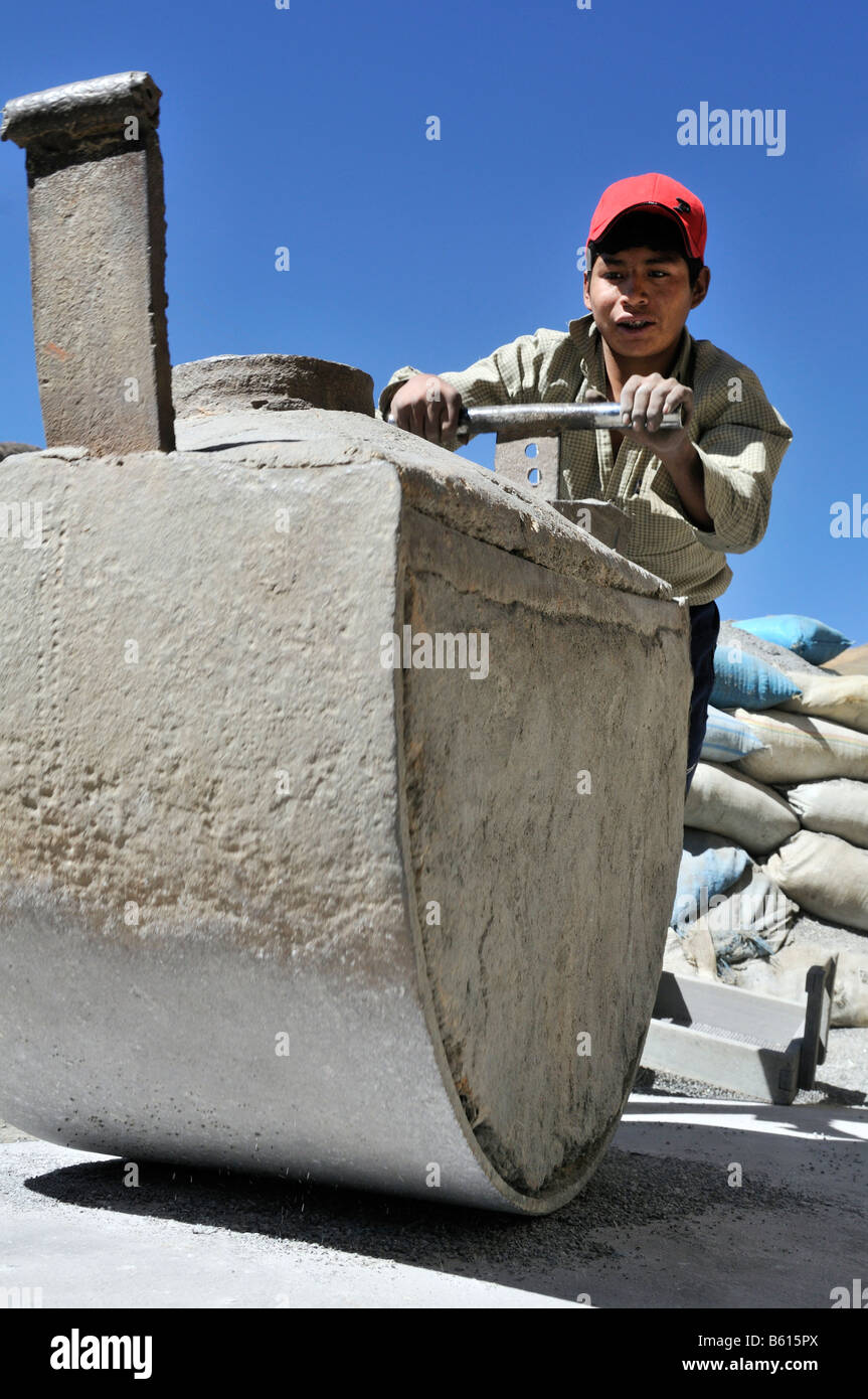 Le travail des enfants, garçon de 14 ans meule en pierre contenant des minerais, de l'étain, le zinc, en une poudre fine, centre minier de Llallagua, Potosi Banque D'Images