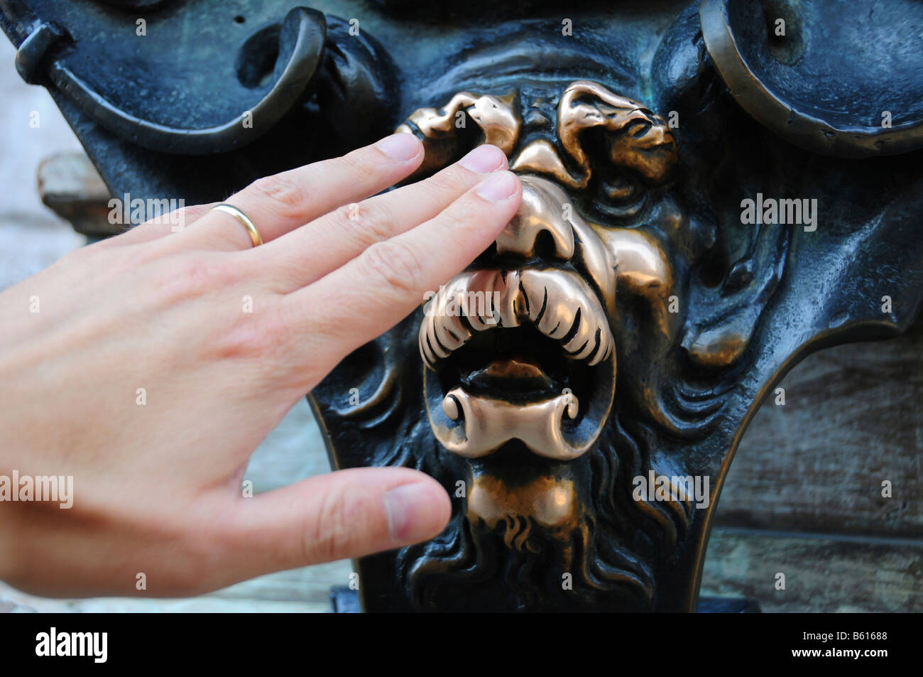 Main sur un lion de bronze en face de la Residenz, quiconque il est accordé un vœu, Munich, Bavière Banque D'Images