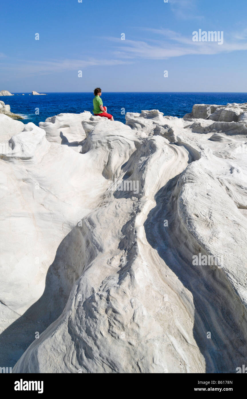 Femme assise sur des rochers blancs sur l'île de Milos, Cyclades Island Group, Grèce, Europe Banque D'Images
