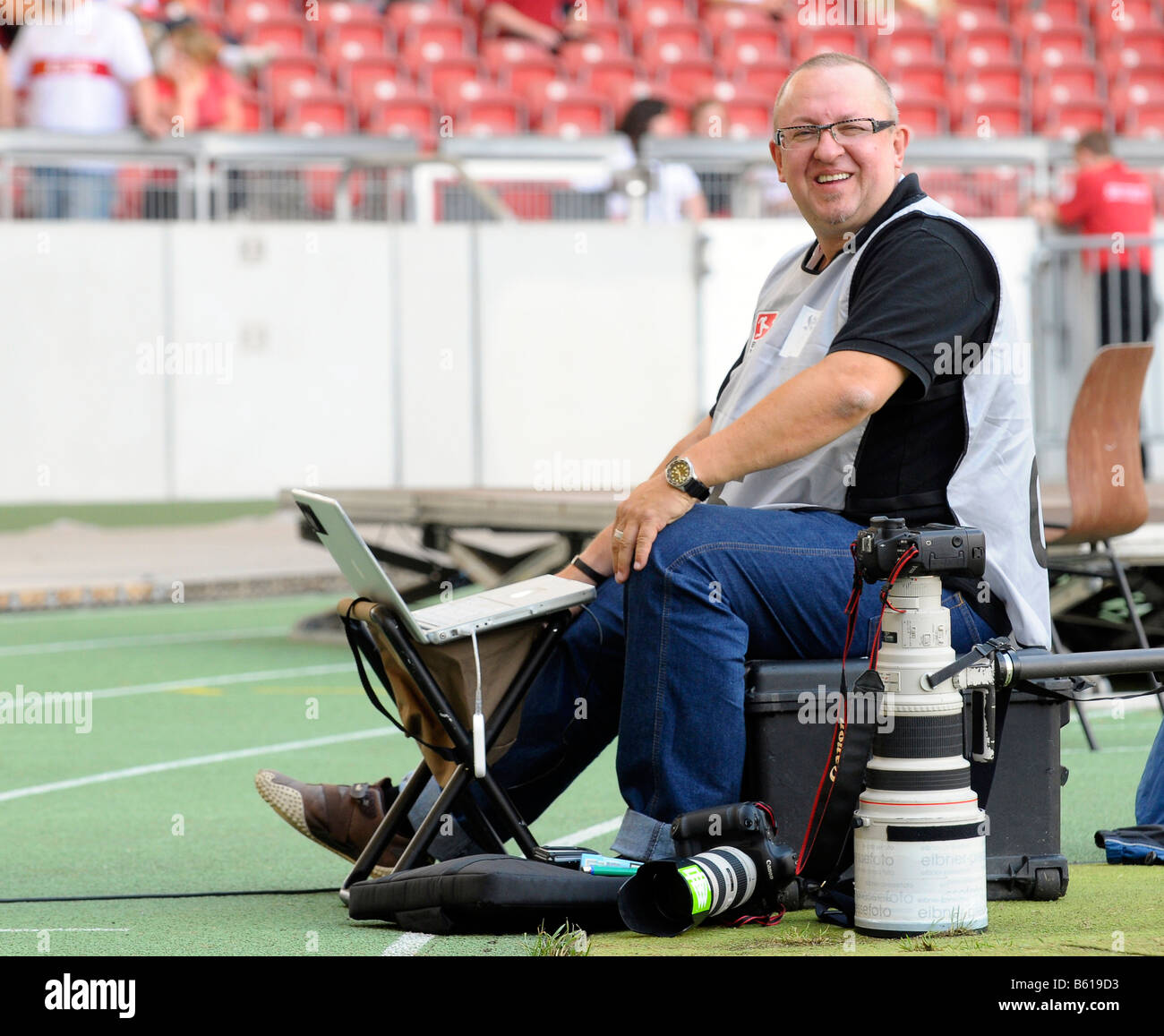 Photographe de presse dans le stade au bord du terrain de jeu avec équipement Canon et Coffre Banque D'Images